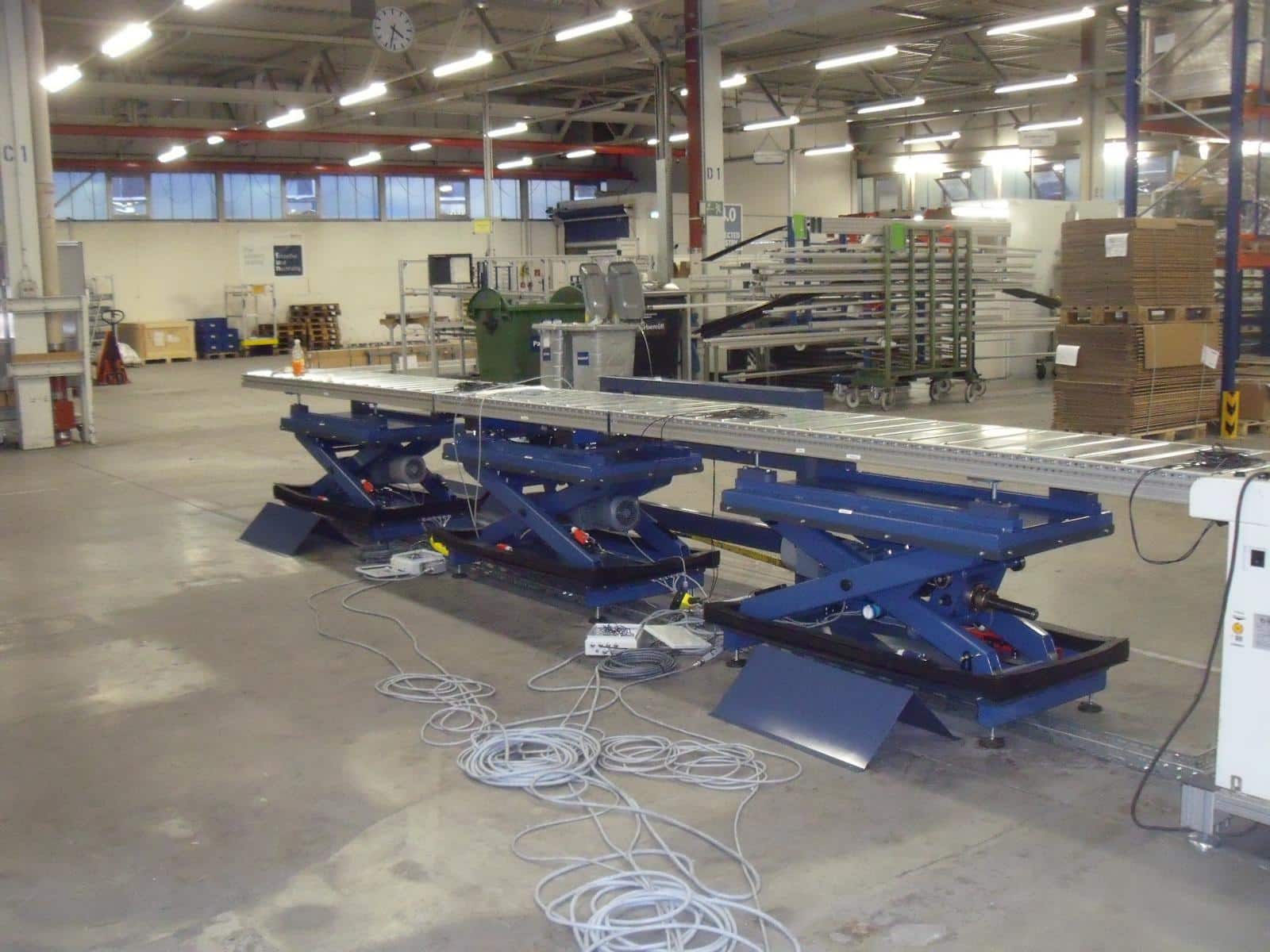 Spindle-driven lifting tables in a conveyor system